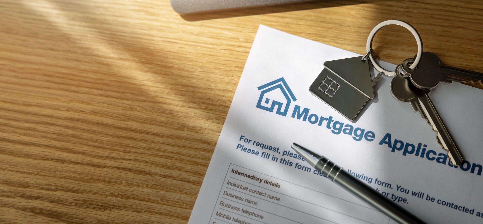 mortgage loan application form and new home keys on the bank office table. copy space